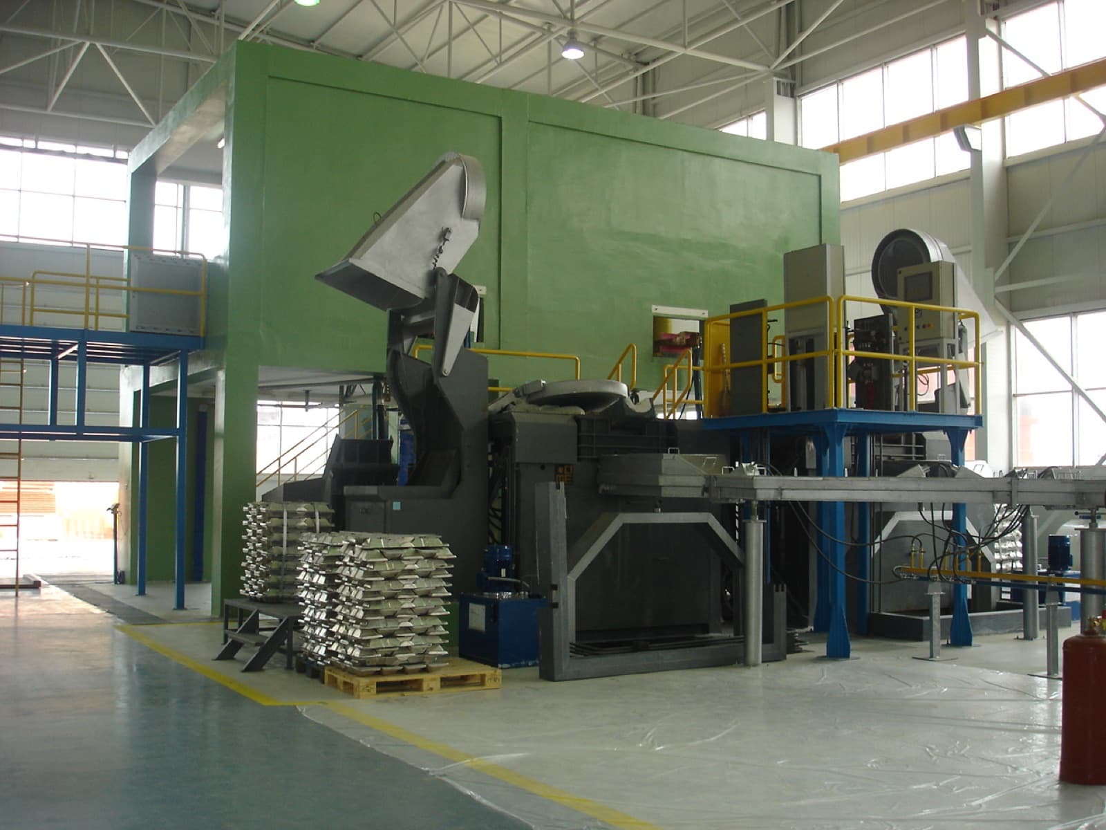 Aluminium melting plant with tilting furnace and stacked ingots
