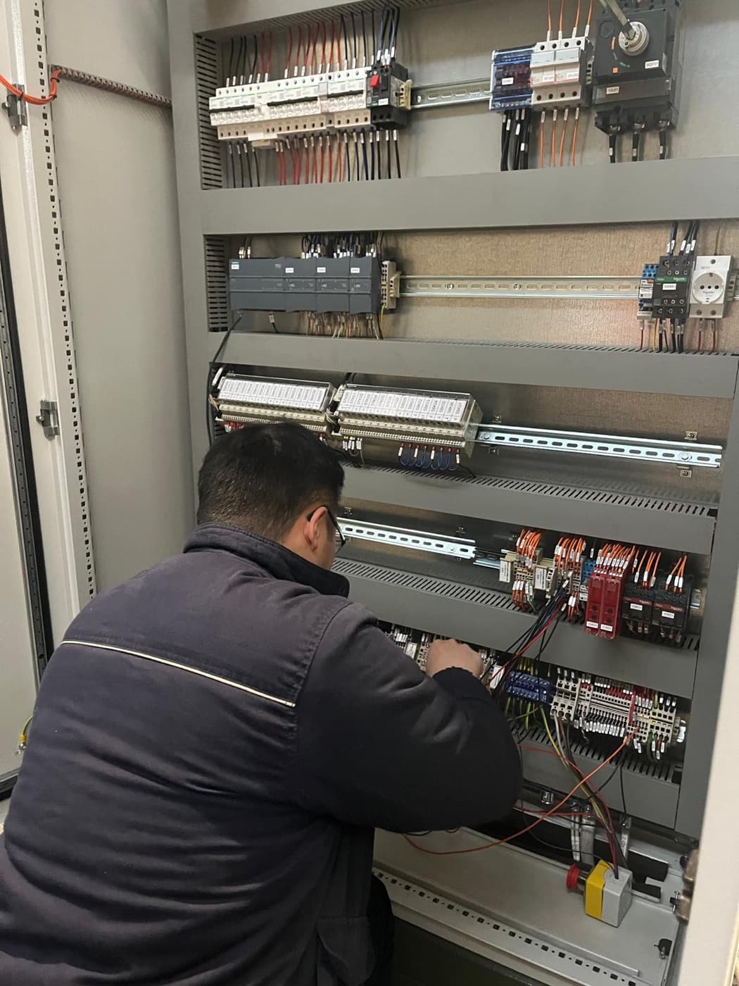 CIME control cabinet: PLC, DIN-rail terminal blocks and wiring for computerized melt control, in the CIME workshop