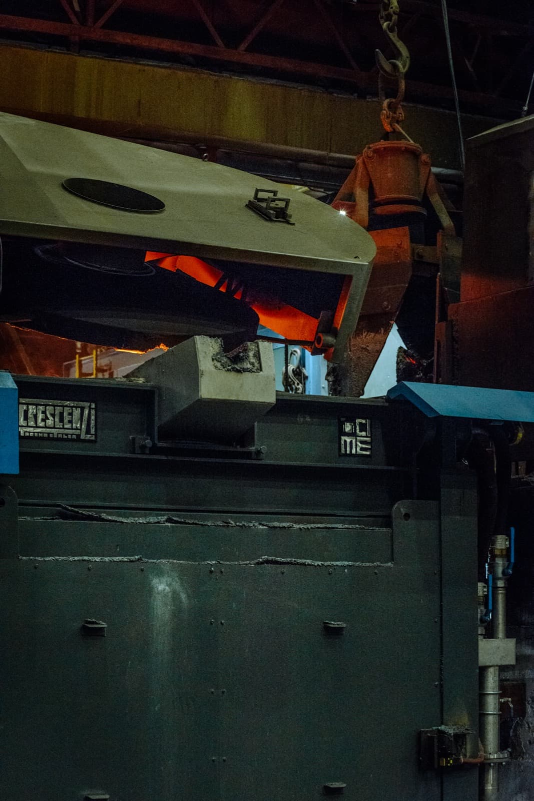 CIME-Crescenzi coreless induction melting furnace with hydraulic tilting body pouring glowing molten metal on the foundry floor