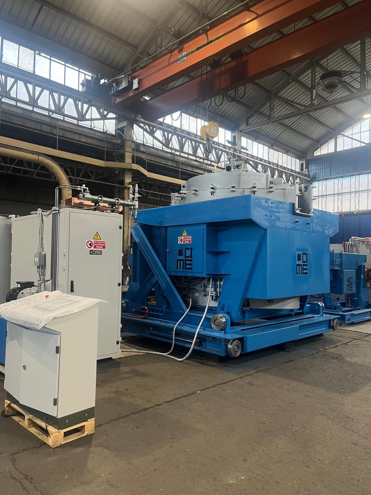 A CIME induction furnace beside its IGBT converter cabinet