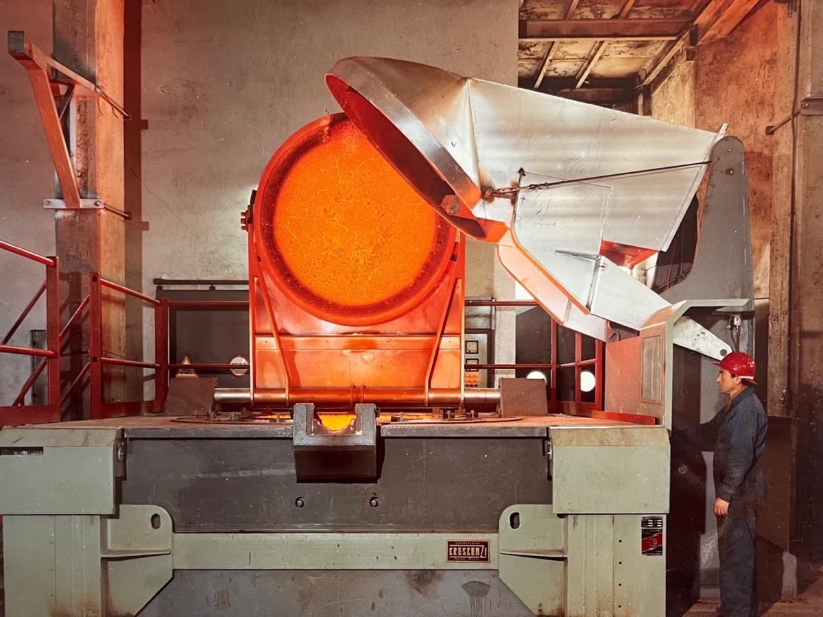 Close-up of a glowing molten metal bath in a coreless induction furnace, the energy of melting visible as incandescent iron